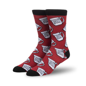 Pair of red crew socks featuring a repeating pattern of white mugs that say 'World's Best Boss'. Black cuff.
