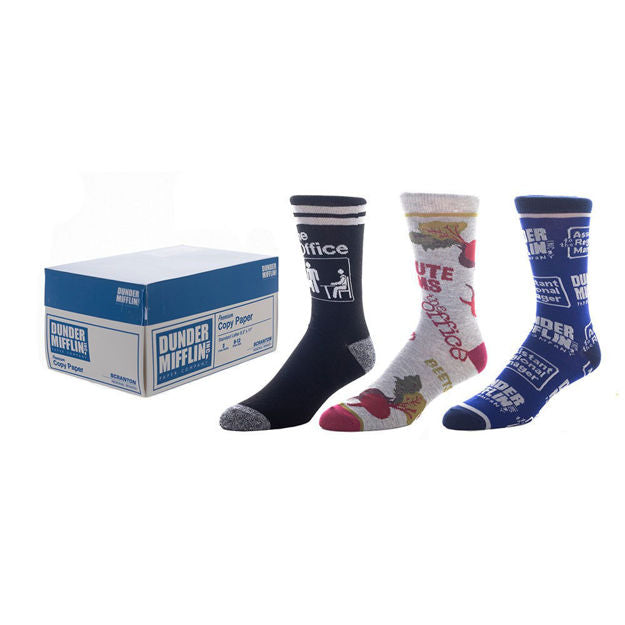 Product shot of three pairs of The Office crew socks. One pair is navy blue with The Office logo, one is gray with beet designs, and one is blue with Dunder Mifflin branding.