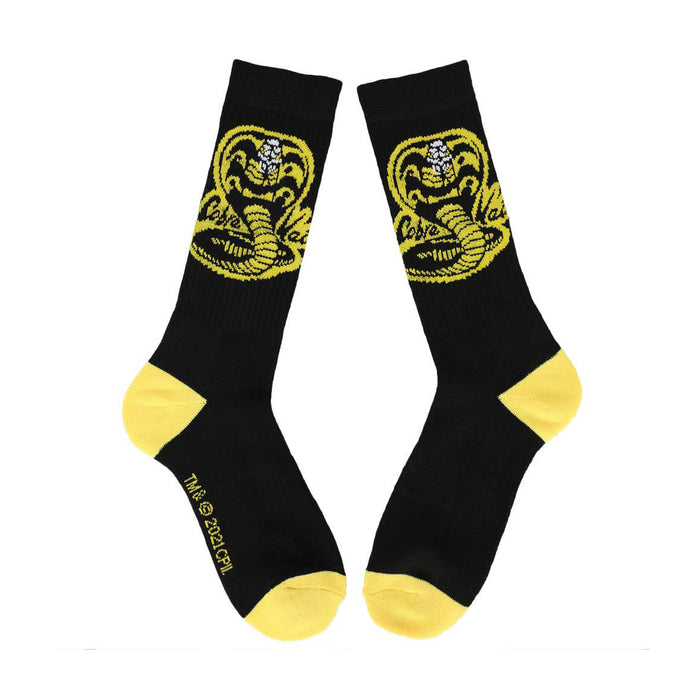 Flatlay product shot of a pair of black Cobra Kai socks with yellow accents showing the full Cobra Kai logo.