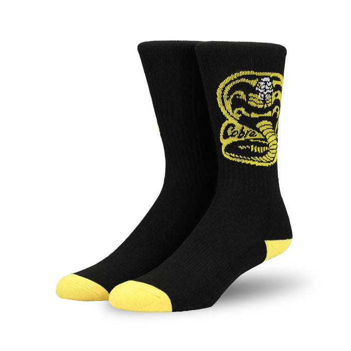 Pair of black crew socks with a yellow Cobra Kai logo. Yellow accents at the heel and toe.