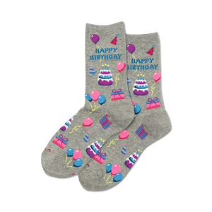 Pair of grey crew socks with a 'Happy Birthday' design. Features purple, pink, and blue pixelated cakes, balloons, and gifts.