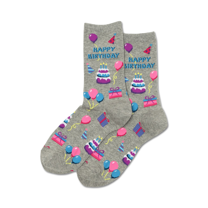 Pair of grey crew socks with a 'Happy Birthday' design. Features purple, pink, and blue pixelated cakes, balloons, and gifts.