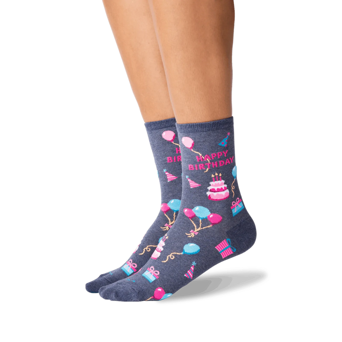 Lifestyle shot showcasing a woman's legs wearing the dark grey 'Happy Birthday' crew socks. The socks' design is clearly visible.