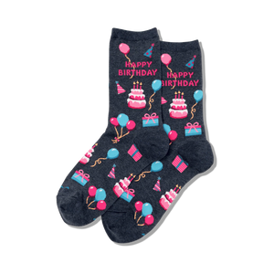 Pair of dark grey crew socks showcasing a 'Happy Birthday' theme. Pink, blue, and white pixelated cakes, balloons, and presents decorate the socks.