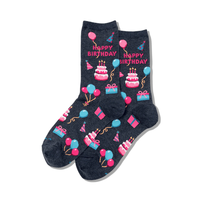 Pair of dark grey crew socks showcasing a 'Happy Birthday' theme. Pink, blue, and white pixelated cakes, balloons, and presents decorate the socks.