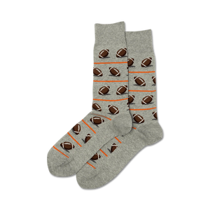 A pair of gray crew socks with a pattern of brown footballs and orange stripes.