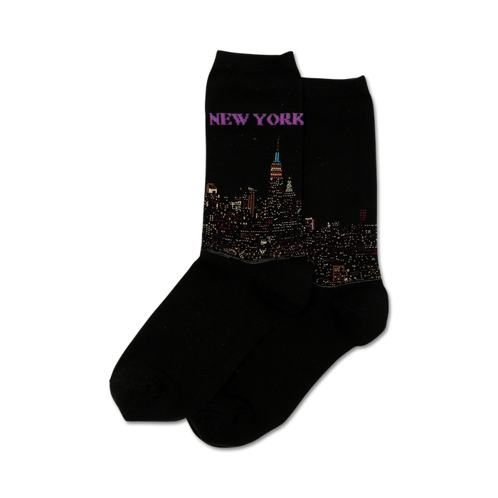 Pair of black crew socks with a detailed New York City skyline at night image and 'NEW YORK' written above it in purple. }}