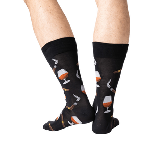 A pair of black socks with a pattern of cognac glasses and cigars.