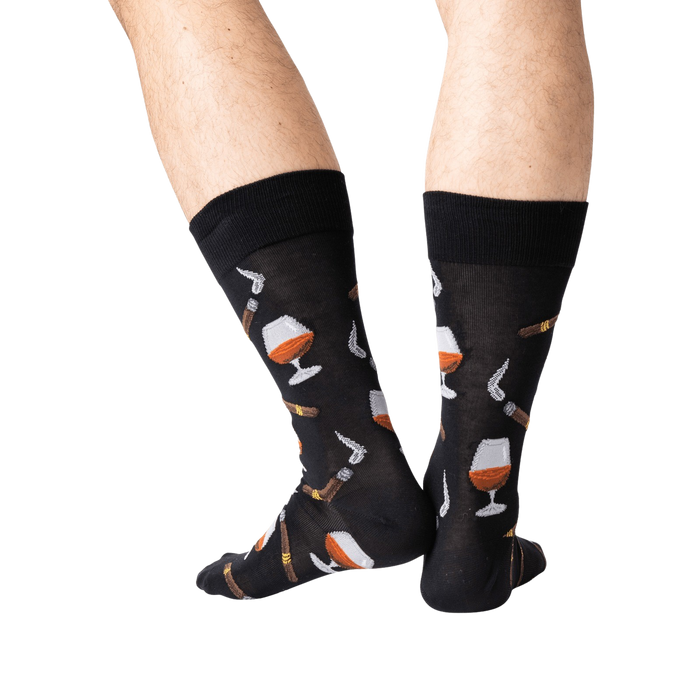 A pair of black socks with a pattern of cognac glasses and cigars.