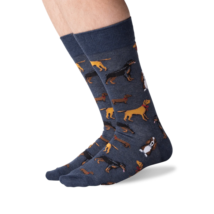 Lifestyle shot showing a person wearing a pair of dark grey crew socks with a repeating pattern of various dog breeds.