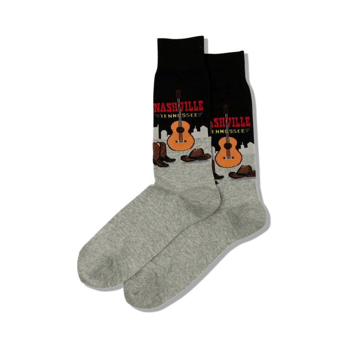Pair of crew socks; black and grey with a Nashville, Tennessee design featuring a guitar, cowboy boots, and hats.