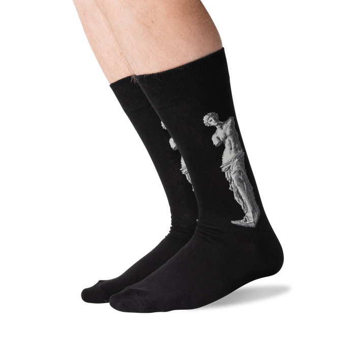 Lifestyle shot of a person's legs wearing the Venus de Milo socks. The socks are black with a white image of the Venus de Milo.