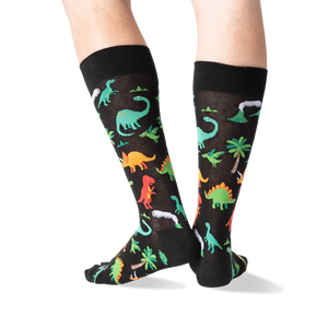 Back view of the dinosaur socks on a person's legs, highlighting the design details.