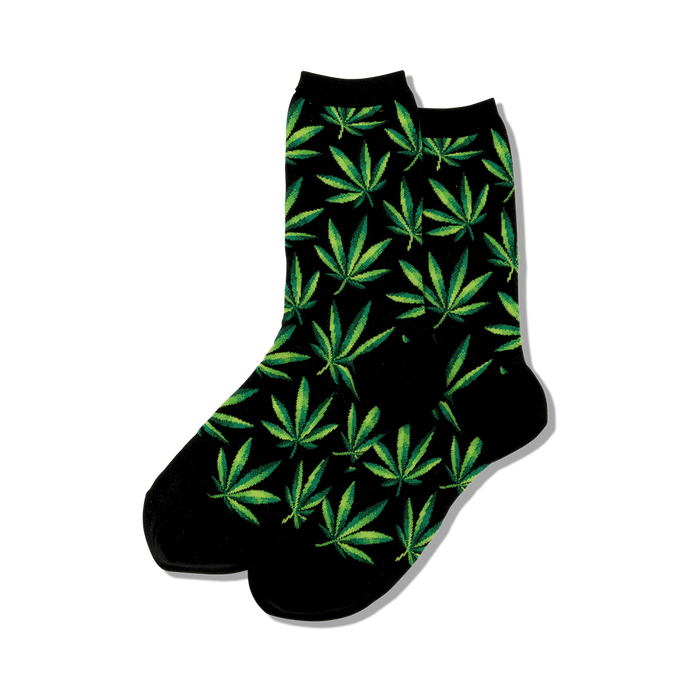 Close-up view of black crew socks with green marijuana leaf pattern.