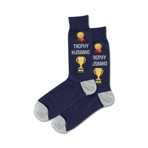 Lifestyle flatlay image showing a pair of navy 'Trophy Husband' socks.