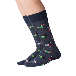 Close-up of a person's legs wearing dark gray Christmas dog socks against a black background.