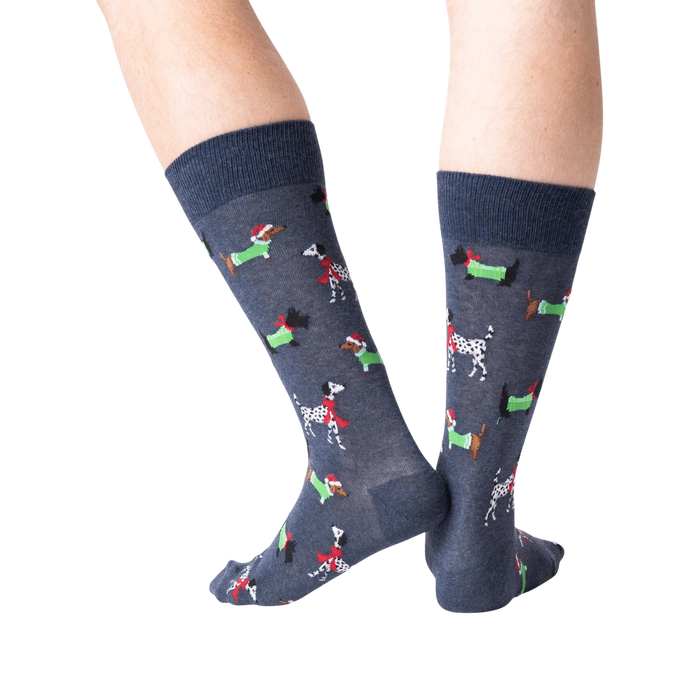 A pair of blue socks with a pattern of cartoon dachshunds wearing Santa hats and scarves.