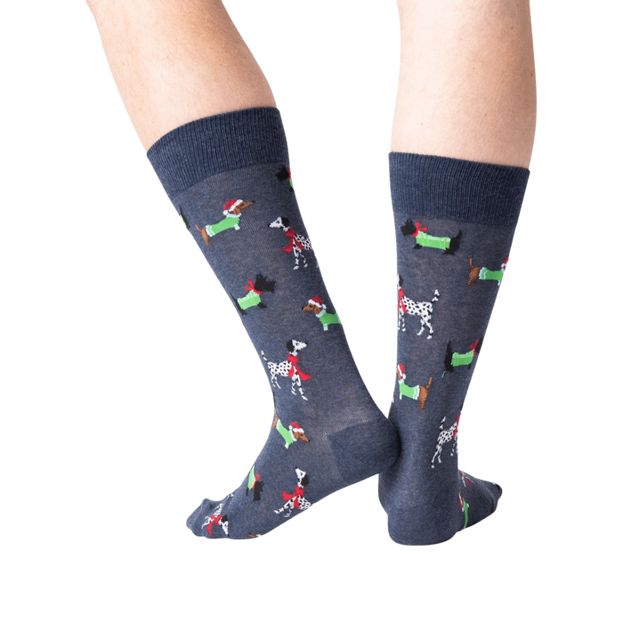Back view of a person's legs wearing dark gray Christmas dog socks against a black background.