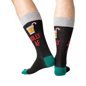 Back view of a person wearing black 'Jolly AF' socks; shows off the full design on the back of the socks.
