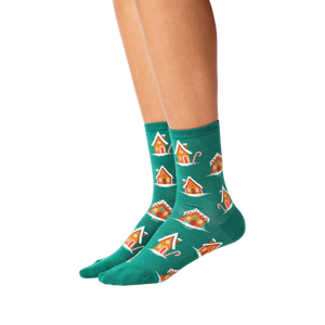 Lifestyle shot of a person's legs wearing the teal gingerbread house socks.