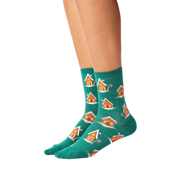 Lifestyle shot of a person's legs wearing the teal gingerbread house socks.