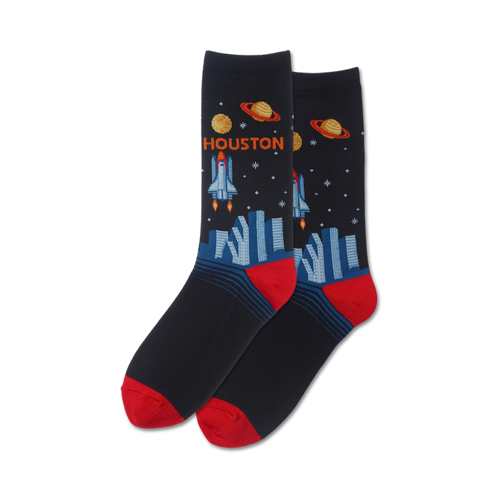 Pair of crew socks in navy blue, featuring a rocket launching over a city skyline, planets, and the word 'HOUSTON'. Red accents on the heel and toe. }}