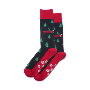 Pair of crew socks in navy and red, featuring a pattern of red trucks carrying Christmas trees and snowflakes on the bottom.