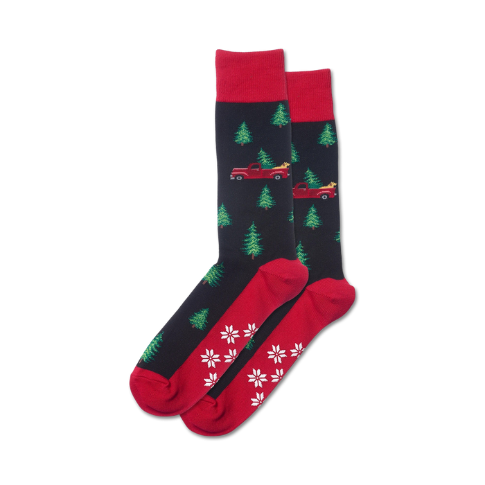 Pair of crew socks in navy and red, featuring a pattern of red trucks carrying Christmas trees and snowflakes on the bottom.
