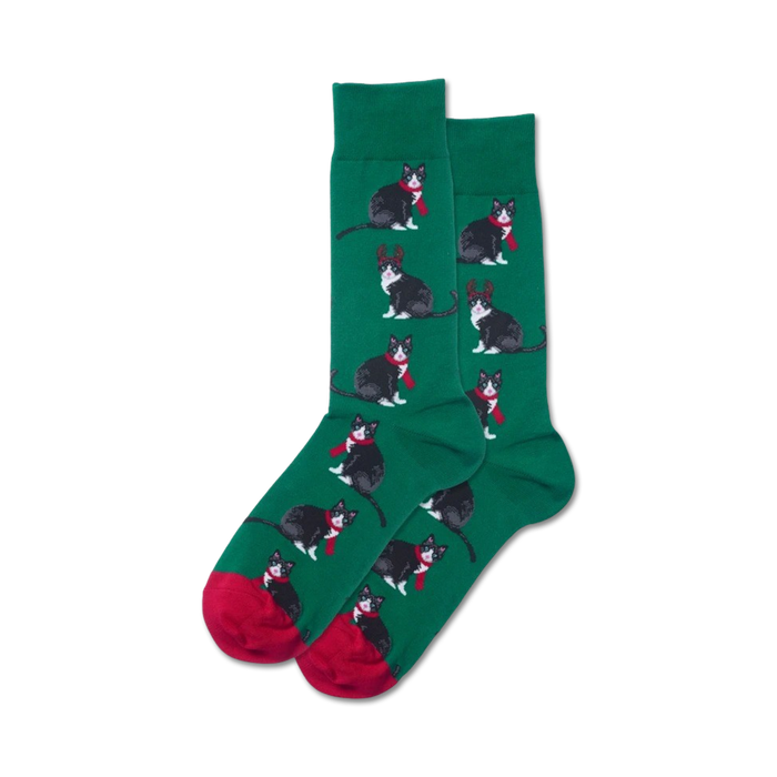 Close-up showing green crew socks with the same reindeer cat design, red cuffs.