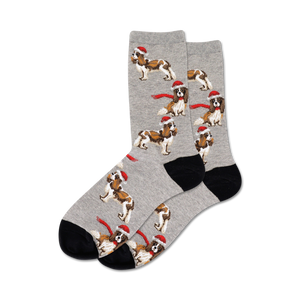 Pair of crew socks in grey with a pattern of Cavalier King Charles Spaniels wearing Santa hats and red scarves. Black heel and toe.