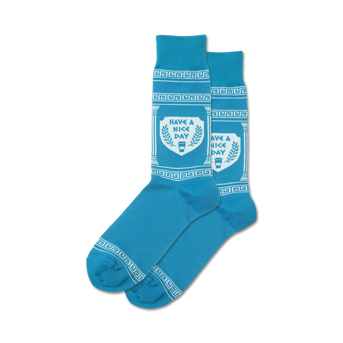 Pair of blue crew socks with a white Greek key border and central design that says, 'Have A Nice Day' inside a shield with coffee cup graphic. }}