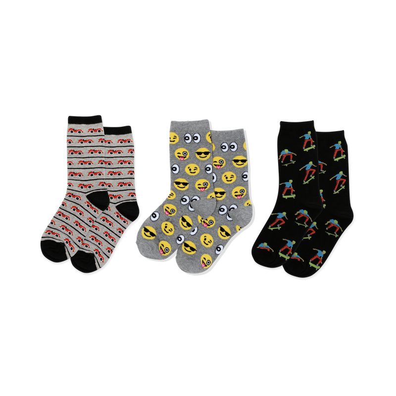 Three pairs of crew socks: light gray with red cars, gray with yellow emojis, black with colorful skateboarders, all with black accents.