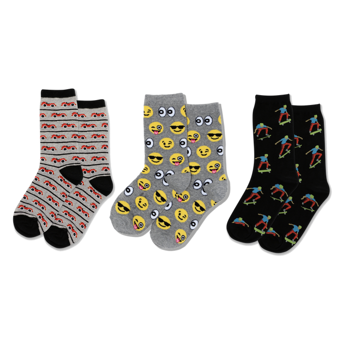 Three pairs of crew socks: light gray with red cars, gray with yellow emojis, black with colorful skateboarders, all with black accents. }}