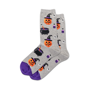 Pair of grey crew socks with purple cuffs. Features a whimsical Halloween design: witch pumpkins, cauldrons, potion bottles, and skulls.