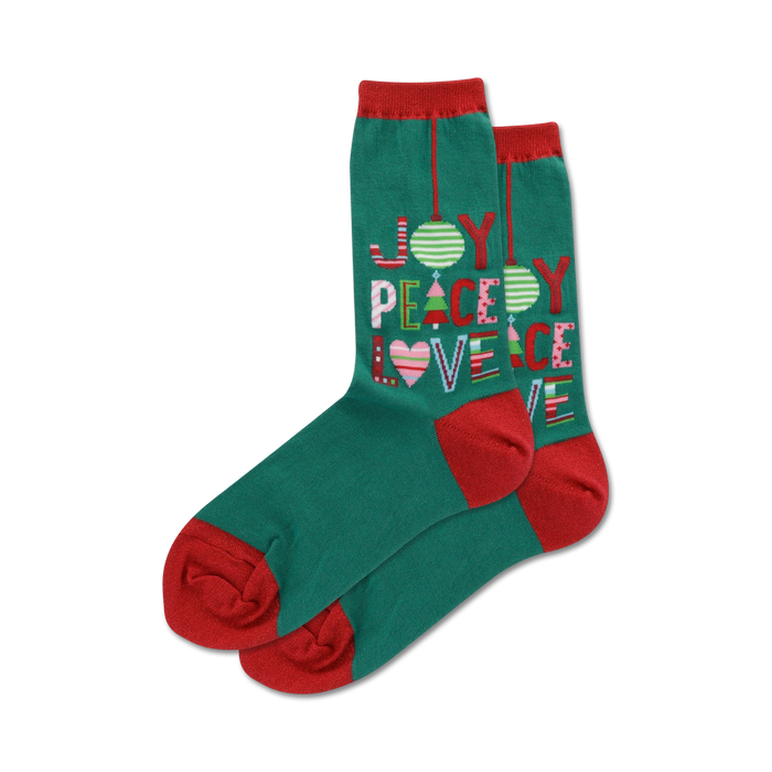 Pair of teal crew socks with red cuffs. Features a colorful 'Joy Peace Love' design incorporating Christmas ornaments and trees.