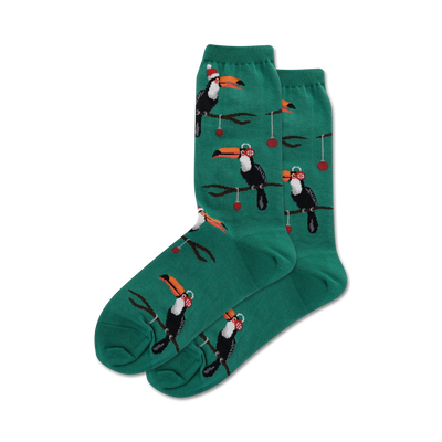 Pair of teal crew socks with a repeating pattern of toucans wearing Santa hats and ornaments hanging from branches.