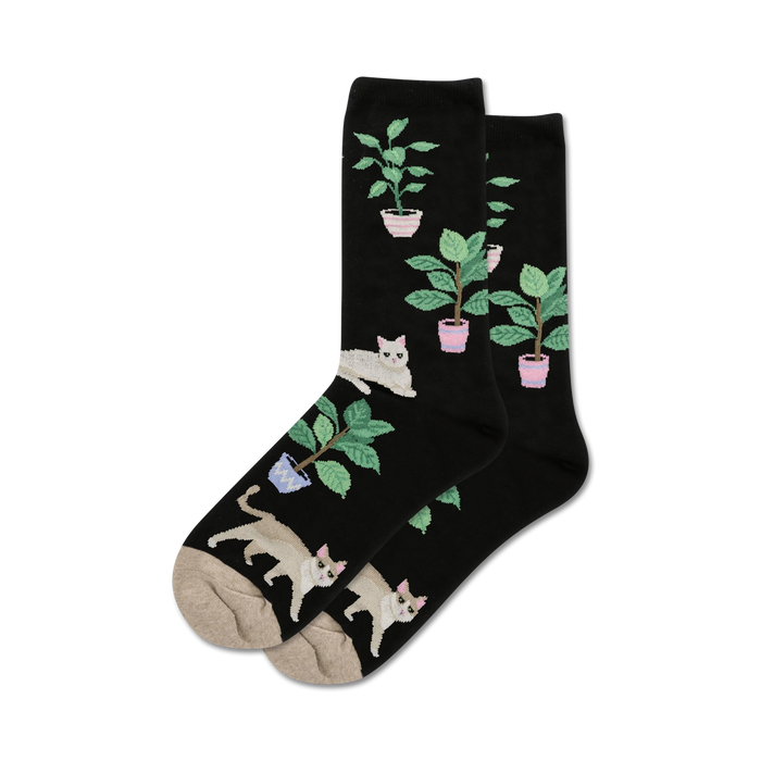 Pair of black crew socks with a whimsical design. Features illustrations of white cats and green potted plants. }}