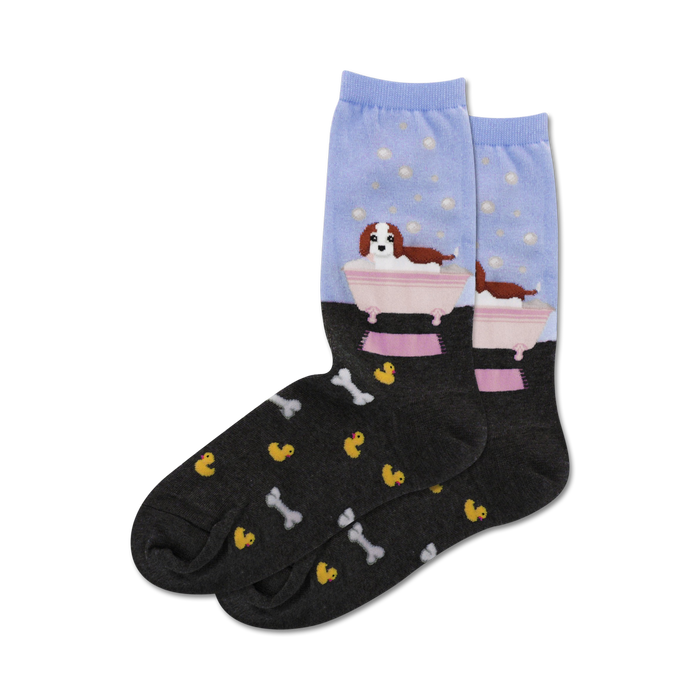 Crew socks in light blue and dark grey. Feature a Cavalier King Charles Spaniel in a bathtub with bubbles, and a pattern of rubber duckies and bones.
