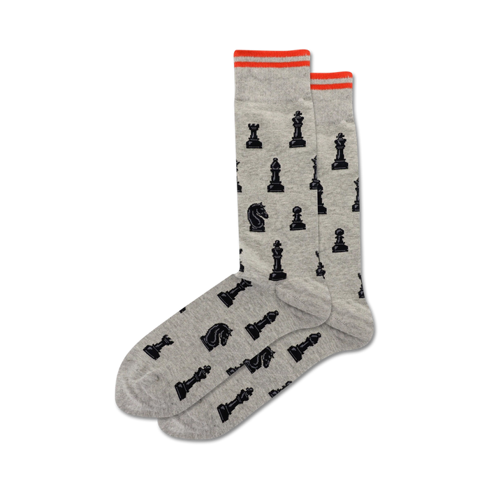 Pair of gray crew socks with a pattern of black chess pieces.  Features orange trim at the top. }}