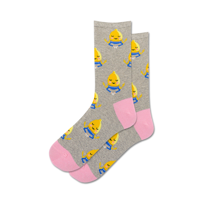 Pair of crew socks, grey and pink, featuring a pattern of cute meditating lemons.