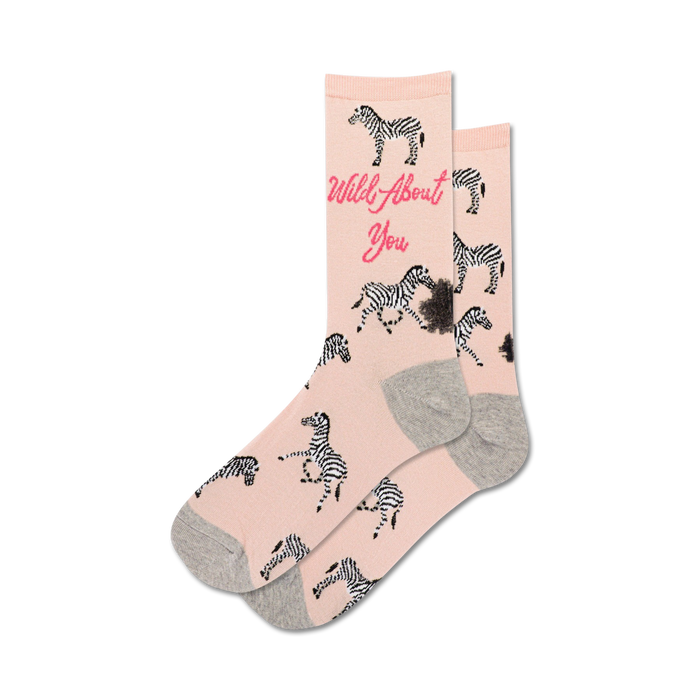 Pair of blush pink crew socks with black and white zebras and the text 'Wild About You'. }}