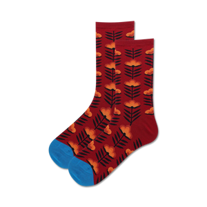 Lifestyle shot:  A pair of burgundy crew socks with an orange retro floral design are casually displayed.
