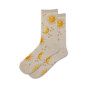 A pair of beige crew socks with a gold sun, moon, and stars pattern.