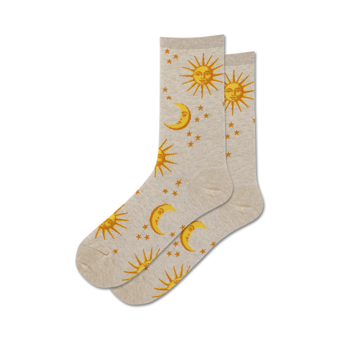 A pair of beige crew socks with a gold sun, moon, and stars pattern.