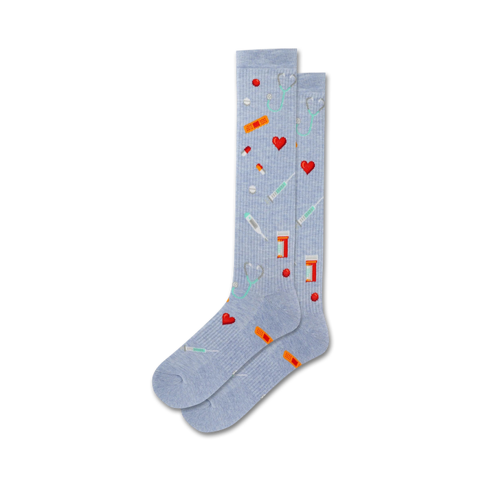 Pair of light blue crew socks with pixel art of hearts, band-aids, pills, stethoscopes, and syringes. }}