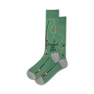 Lifestyle shot showing the green 'Hooked On You' socks on a person's feet. The socks feature a fishing-themed design.