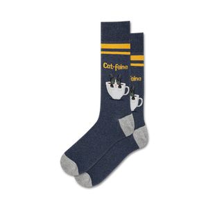 Pair of navy blue crew socks with grey cuffs. Features a cute tuxedo cat in a coffee cup design and yellow stripes.