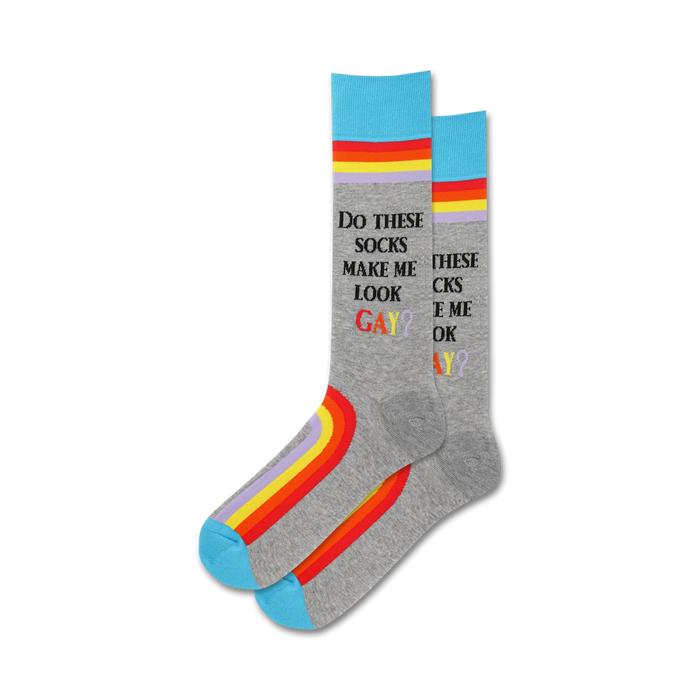 A pair of grey crew socks with rainbow stripes along the bottom and text that says,
