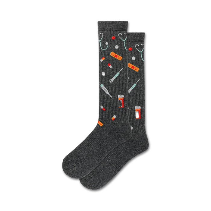 Pair of dark grey crew socks with a pattern of colorful medical icons: stethoscopes, pills, bandages, and syringes. }}