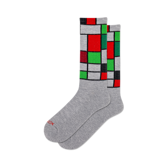 Pair of gray crew socks with a Mondrian-inspired geometric design in red, green, and black on gray background.